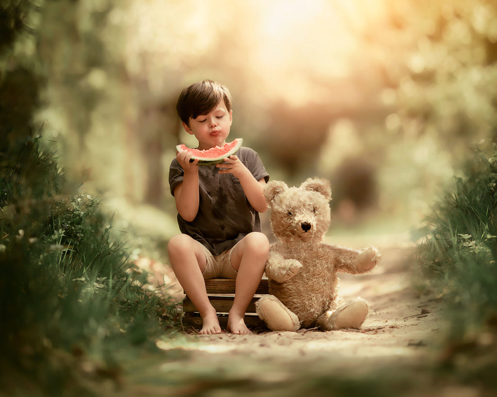 Canon Fine art spring portrait of a young boy eating a water melon in the forest by Dutch photographer Willie Kers