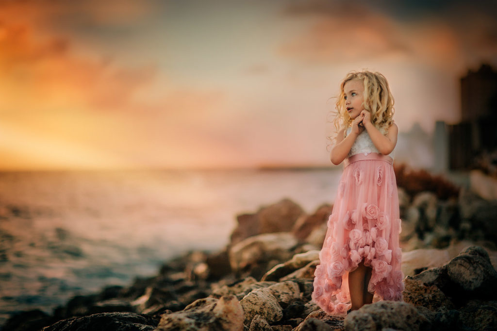 Canon golden hour portrait of a mesmerized little girl in a pink dress watching a beautiful sunset at Pietermaai Beach Curacao by Willie Kers