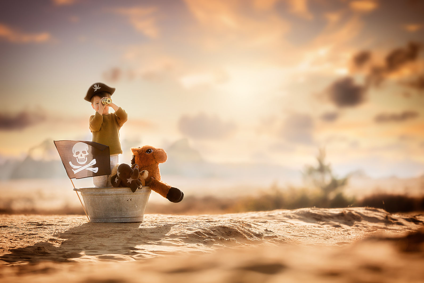 Fine art child portrait of a little pirate boy sailing in the desert by dutch natural light photographer Willie Kers