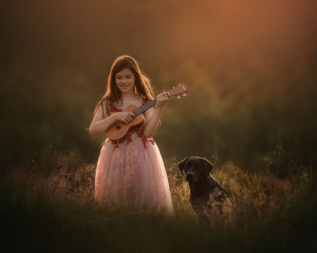 fine art portret van een meisje met een hond en gitaar tijdens zonsondergang door natuurlijk licht fotograaf willie kers uit apeldoorn