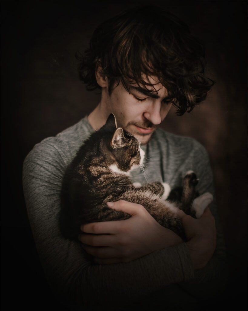 foto van een jonge man met een kat in zijn armen door natuurlijk licht fotograaf Willie Kers uit Apeldoorn